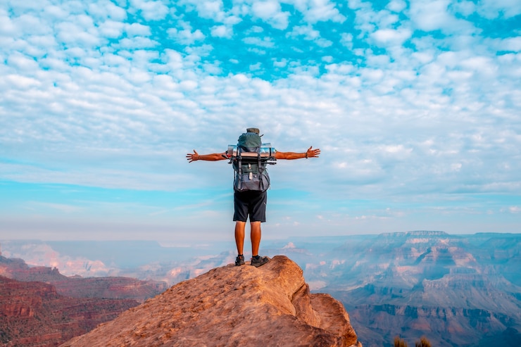Photo détail d'un jeune homme à bras ouverts sur un point de vue de la descente du south kaibab trailhead. grand canyon, arizona