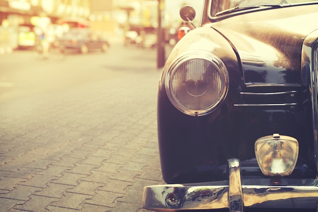 Détail de la lampe phare voiture classique garée en milieu urbain - style effet filtre vintage
