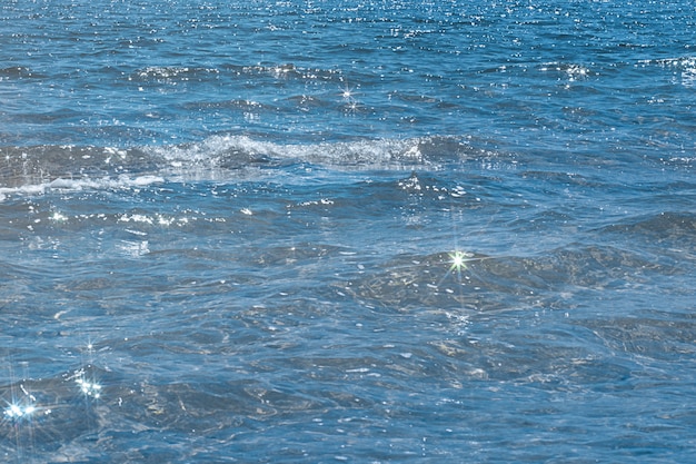 Détail d'une lumière du soleil se reflétant dans la mer scintillante. Concept de nature puissante et paisible.