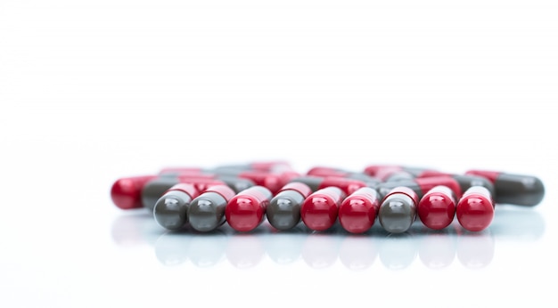 Détail macro shot de pilules gélules rouges et gris isolés