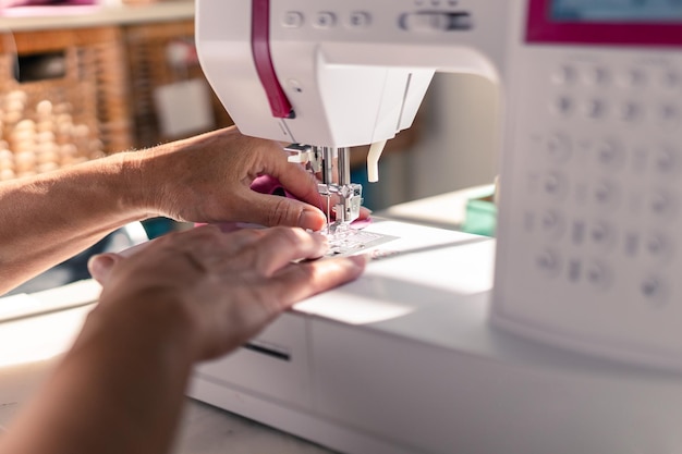 Détail des mains d39une femme cousant avec une machine à coudre