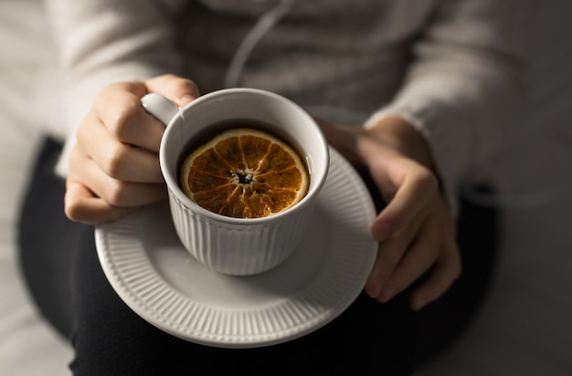 Photo détail des mains de femme tenant une tasse de thé vu d'en haut