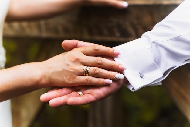 Photo détail des mains de la mariée et du marié avec des anneaux lors d'une cérémonie de mariage