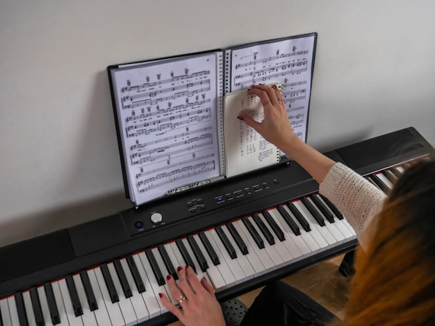 Détail d'une personne jouant du piano à la maison