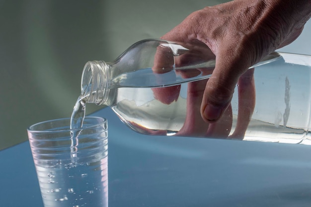 Détail de la personne remplissant le verre d'eau concept d'hydratation