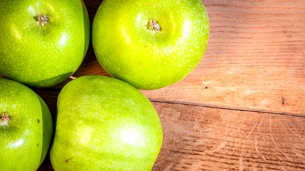 Photo détail sur des pommes vertes mûres sur une table en bois