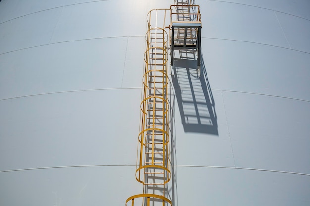 Détail des réservoirs blancs de propane dans le réservoir avec échelle d'escalier en fer.