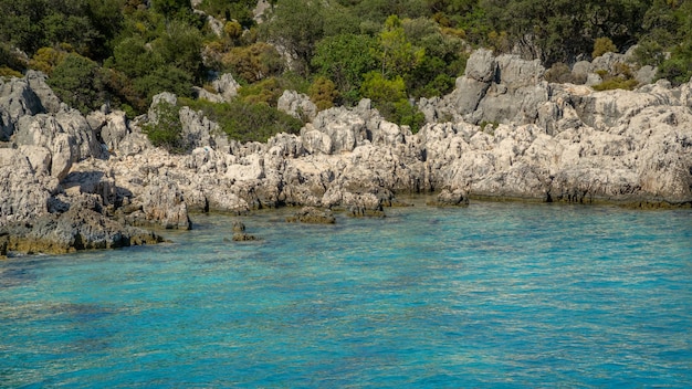 Détail des rochers au-dessus de la mer avec l'eau turquoise transparente en Turquie