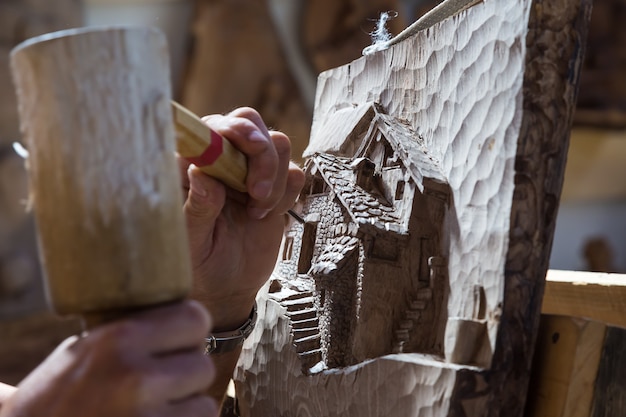 Détail de scultor d'âge moyen caucasien travaillant sur bois, lumière naturelle