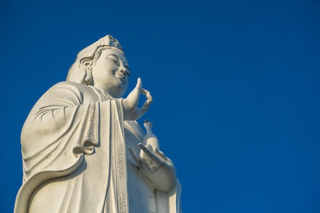 Détail de la statue de Lady Buddha dans un temple bouddhiste et fond de ciel bleu à Danang Vietnam Closeup copy space