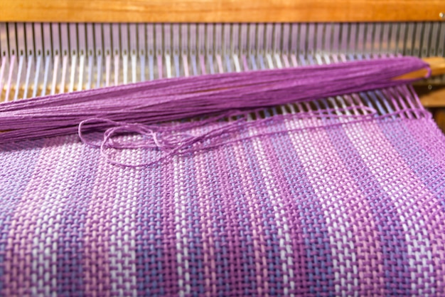 détail de tissu dans le peigne à tisser avec des couleurs ultraviolettes et lilas