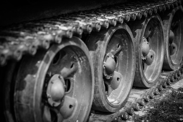 Détail tourné avec de vieilles chenilles et roues de chars en noir et blanc dramatique. Guerre monochrome