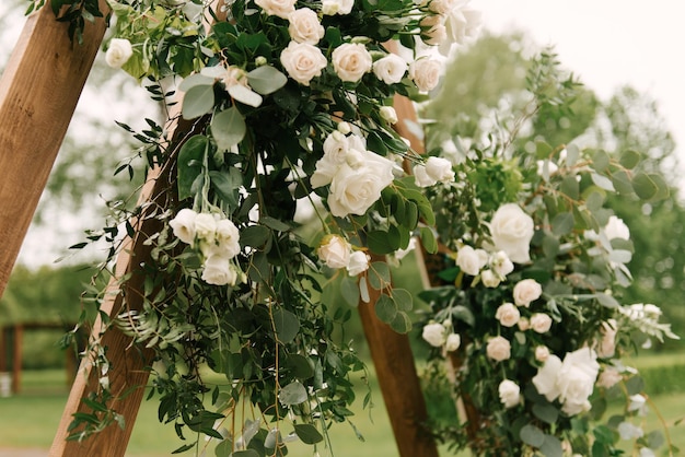Détails du décor de mariage l'arc pour les jeunes mariés en bois décoré de fleurs fraîches rose et eucalyptus