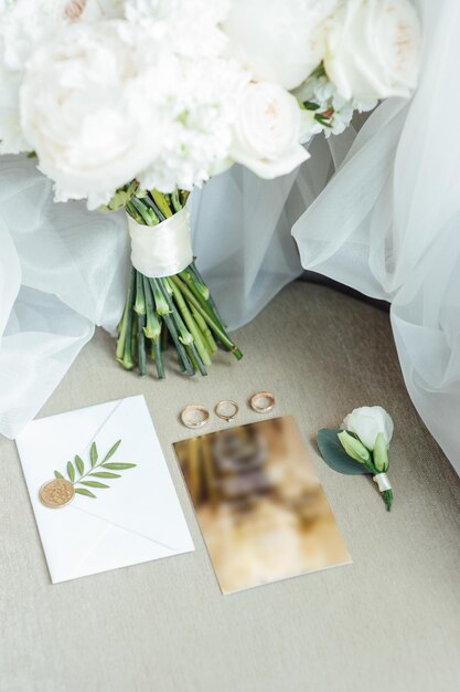 Détails du mariage à plat. Faire-part de mariage et papier de défilement. Flacon avec parfum. Bouquet simple