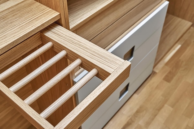 Détails internes de l'armoire en bois avec support coulissant pour cintre et portes d'armoire gris clair