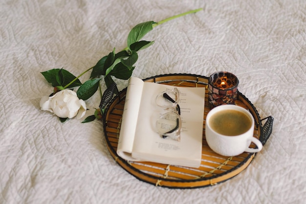 Détails de la nature morte à l'intérieur de la maison du salon Livre ouvert avec des verres tasse de café et bouquet de fleurs de pivoines roses blanches Lire et se reposer Maison confortable