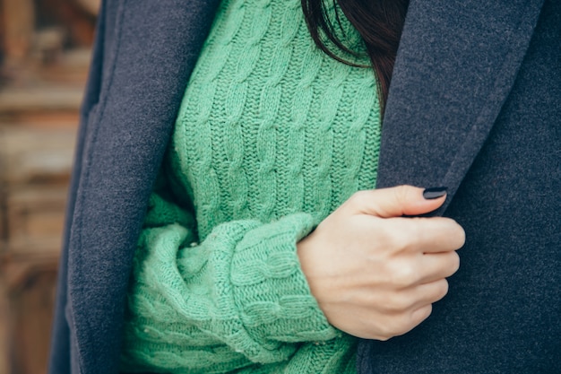 Détails de vêtements pour femmes. Gros plan, main, femme, pull, manteau