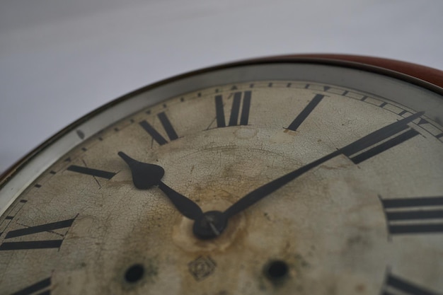 Détails d'une vieille horloge sur un mur blanc