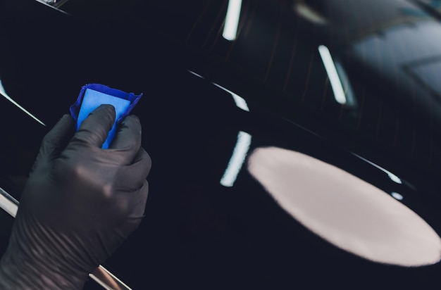 Détails de voiture L'homme applique un revêtement de protection nano sur la voiture Mise au point sélective