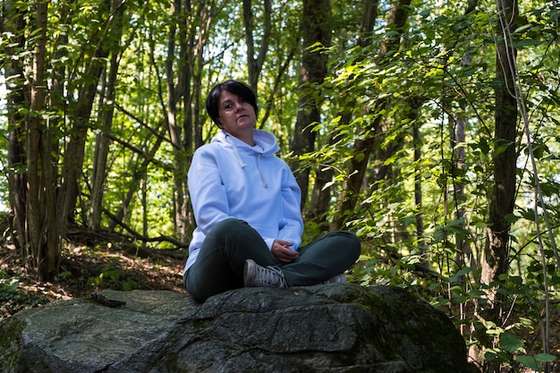 Détendez-vous dans la nature avec une jeune femme dans un yoga et méditation de pleine conscience en forêt