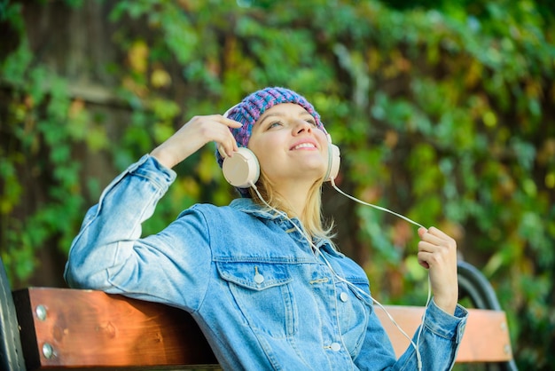 Détendez-vous dans le parc fille hipster se détendre dans le parc avec lecteur mp3 femme hipster dans les écouteurs se détendre dans le parc en écoutant de la musique style de livre audio en plein air et musique technologie moderne au lieu de lire