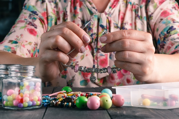 Détendez-vous passe-temps. Femme fait des perles artisanales