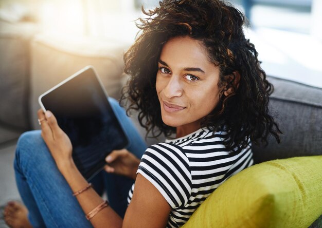 Détendez-vous la tablette et le portrait d'une femme sur un canapé à la maison pour le site Web en ligne du réseau et les médias sociaux Application mobile de communication et femme africaine sur la technologie numérique pour le message de chat et Internet