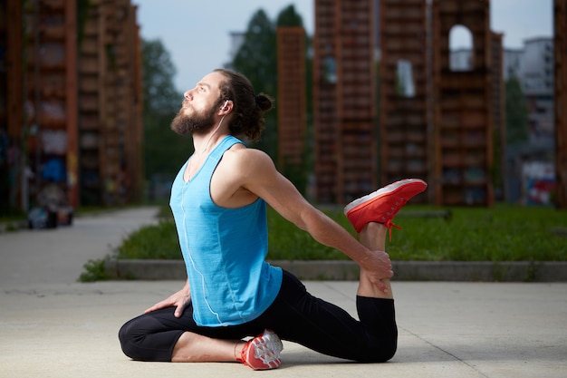 Détendu bel homme faisant des exercices de yoga