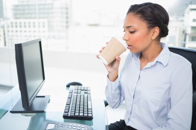 Détendu jeune femme d&#39;affaires aux cheveux noirs, boire du café