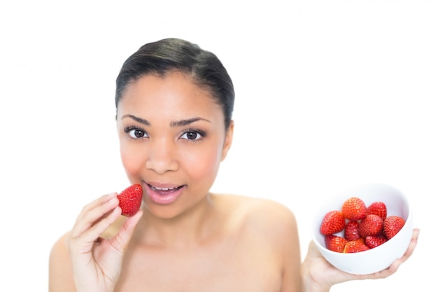 Détendu jeune mannequin aux cheveux sombres, manger des fraises