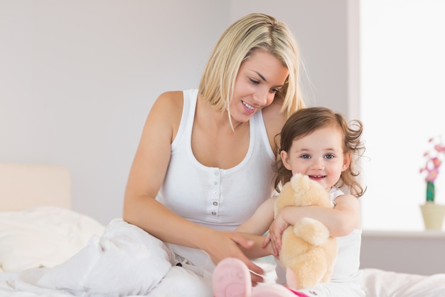 Détendu mère et fille assise sur le lit