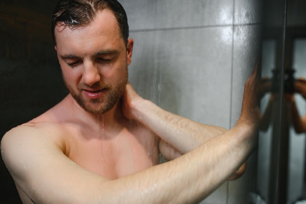 Détente après une journée stressante Portrait à la taille d'un homme musclé nu prenant une douche à la maison