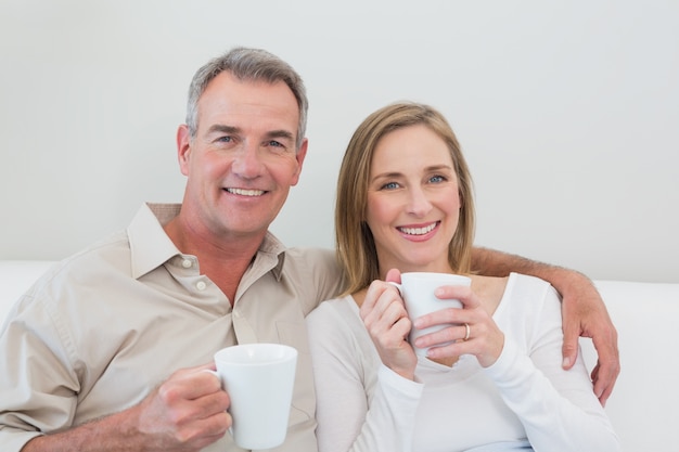 Détente couple d&#39;amoureux avec des tasses de café dans le salon