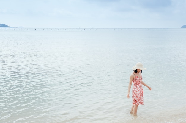 Photo détente femme sur le ciel de la plage et des nuages.