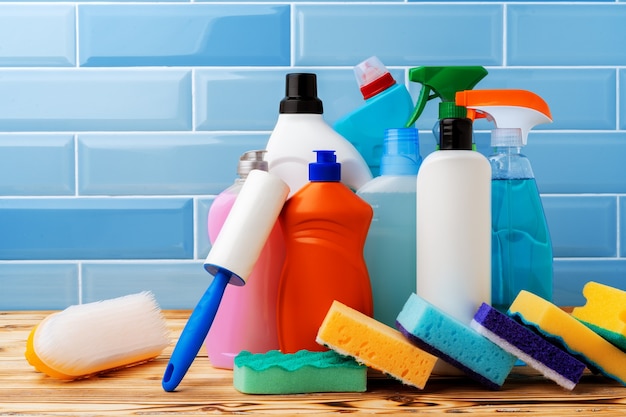 Détergents ménagers et outils de nettoyage sur fond de carreaux bleus