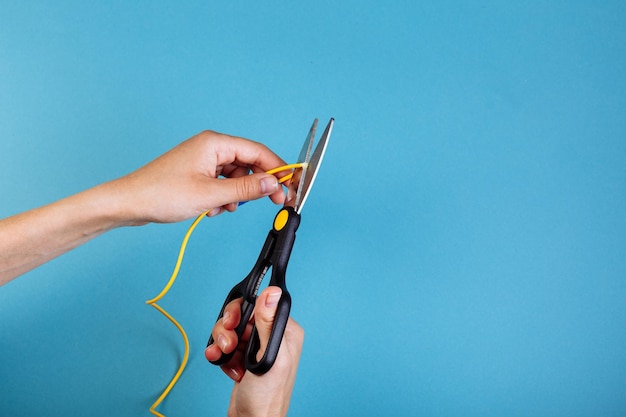 Détruire la fibre optique avec des ciseaux Isolé sur bleu