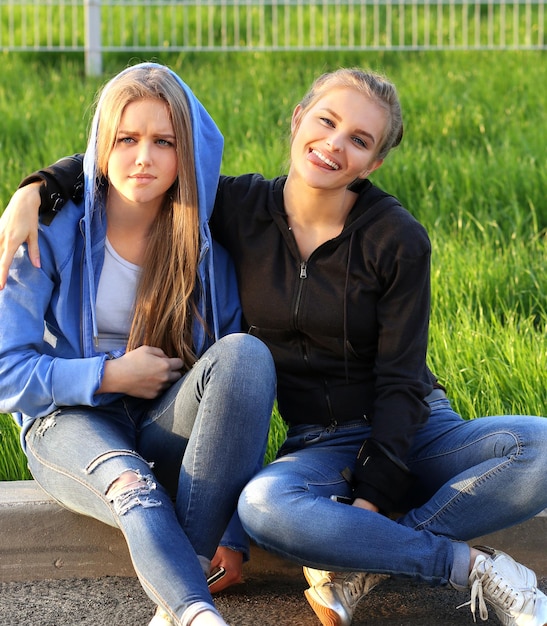 Deux adolescentes assis ensemble à l'extérieur