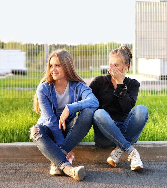 Deux adolescentes assis ensemble à l'extérieur