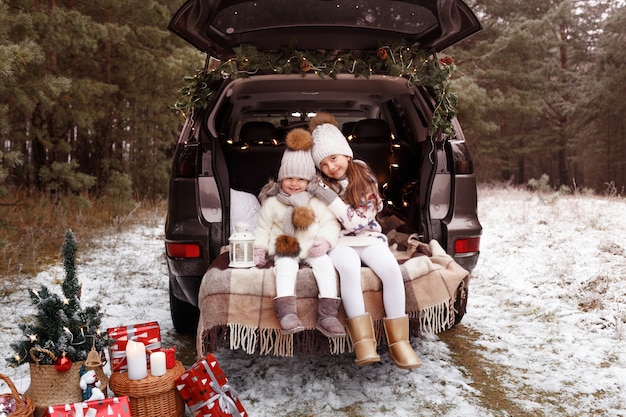 Deux adolescentes s'embrassent dans le coffre d'une voiture décorée de décorations de Noël