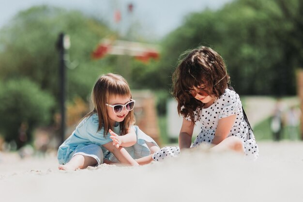 Deux adorables filles jouant sur la plage en été