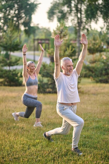 Deux adultes matures sportifs s'exerçant dans le parc