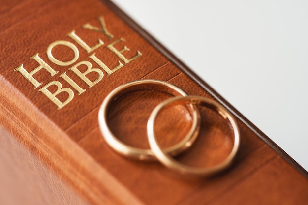 Deux alliances dorées et une sainte bible représentent le concept du mariage et de l'amour entre deux chrétiens