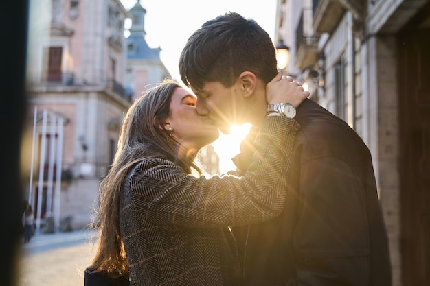 deux amants s'embrassent dans la rue au coucher du soleil un jeune couple passe la Saint-Valentin en couple