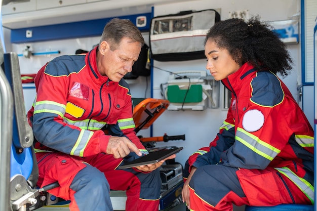 Photo deux ambulanciers assis dans la voiture d'ambulance