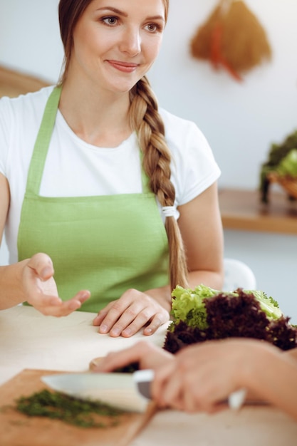 Deux amies choisissent la recette et les ingrédients pour un délicieux repas dans une cuisine ensoleillée Concept végétarien