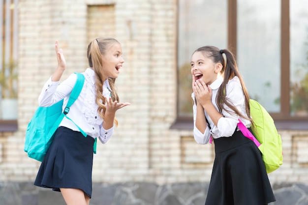 Deux amies d'école plaisantant ensemble en plein air