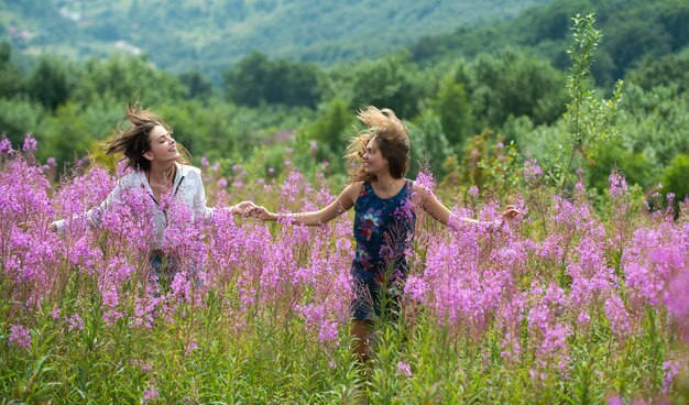 Deux amies. Fille lesbienne insouciante parc ensoleillé nature paysage fond.