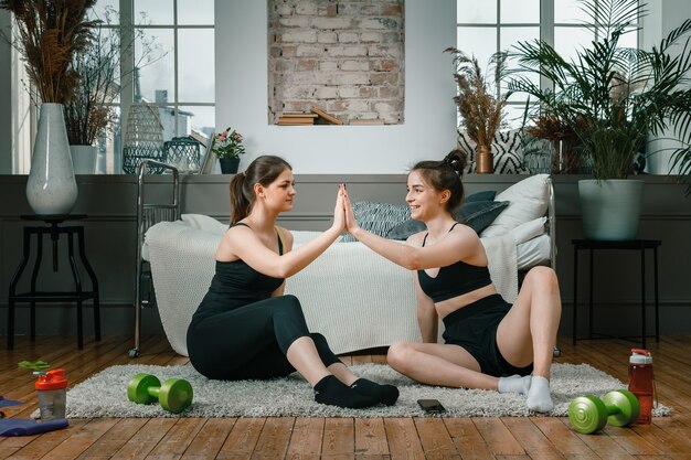 Deux amies à la maison bavardant, souriant et faisant du sport