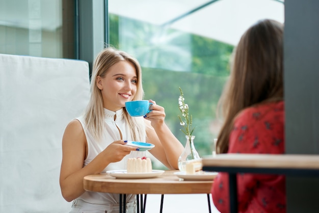 Deux amies prenant un café, discutant.