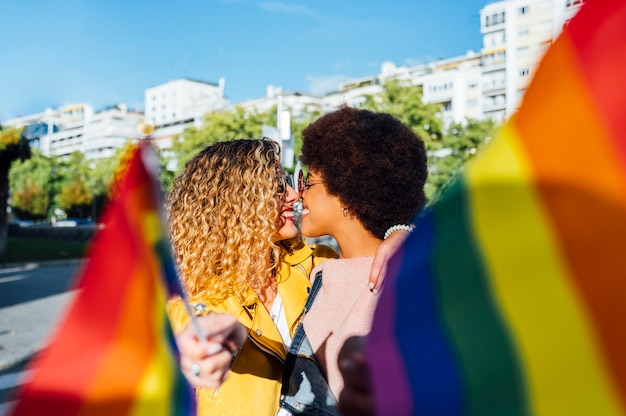 Photo deux amies traîner dans la ville en agitant des lgbt